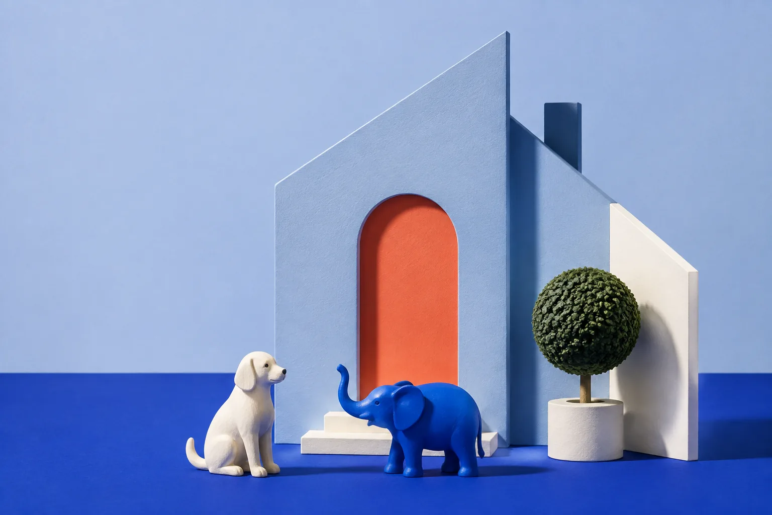 A miniature blue house, a cream dog and a blue elephant figurine beside a coral doorway.